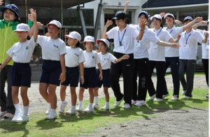 児童生徒らと八月踊りを練習する鹿大の学生＝４日、奄美市名瀬の芦花部小中学校