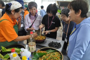 地元住民に教わりながら、郷土料理作りに挑戦するシニア自然大学校の講座生ら＝７日、知名町の農村婦人センター