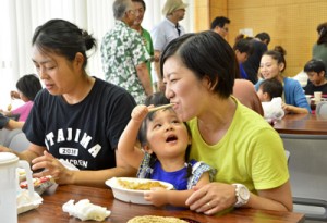 カレーライスを頬張る来場者たち＝２２日、奄美市名瀬