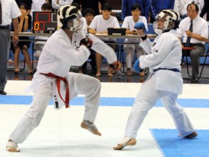 【男子個人組手６８㌔超決勝】奄美勢同士の対決で熱戦を繰り広げた大島の福崎（左）と徳之島の牧山＝１２日、鹿児島市の県体育館