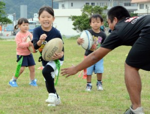  タグラグビーを楽しむ参加児童＝３０日、奄美市名瀬長浜町