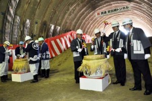 鏡開きを行って宮古崎トンネルの貫通を祝う関係者＝１日、奄美市名瀬の根瀬部側坑口付近