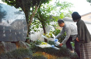 文学碑に献花する島尾伸三さん（奥）ら＝１２日、奄美市名瀬