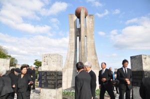 平和の塔へ献花後、石碑に刻まれた、親族や知人の名前を探す参列者ら＝１５日、知名町