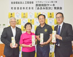 商品をアピールする中村社長（中央右）と向井理事長（同左）＝２６日、奄美市名瀬