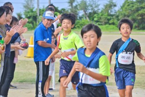 住民の声援を受けながらスタートした１区の選手たち＝３日、与論町