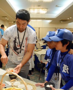 児童らとともにおかずを選ぶ嶺井博希捕手＝１２日、奄美市名瀬