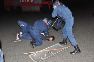 訓練でハイジャック犯を取り押さえる沖永良部署員＝４日、和泊町の沖永良部空港