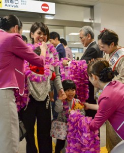 ピーチの乗客を歓迎する地元関係者ら＝２６日、奄美空港