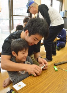 参加した児童に小刀の扱い方を教える満さん＝２２日、奄美市名瀬