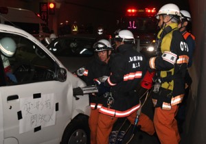 事故車両のドアを解体する消防署員＝１３日、瀬戸内町の網野子トンネル