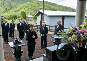 豊さんが眠る共同納骨堂に手を合わせる八重子さんら＝８日、宇検村部連