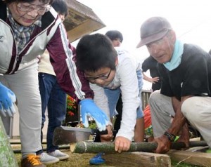 お年寄りから指導を受け、門松作りに挑戦する児童ら＝２６日、伊仙町面縄