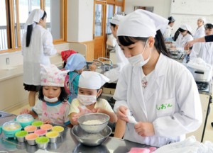 高校生から郷土菓子「ふくらかん」作りを学ぶ園児たち＝１６日、奄美市の県立奄美高校