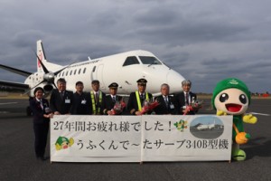 ラストフライトを前にサーブ機の前で記念撮影するＪＡＣ関係者＝２０日、喜界空港