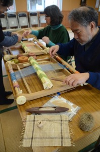 卓上機で、自らが収穫し乾燥させた芭蕉糸を織り、芭蕉布作りに挑戦する参加者＝１２日、宇検村湯湾