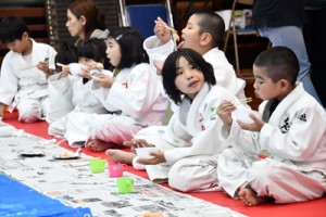 ぜんざいや餅を頬張る児童ら＝９日、奄美市名瀬