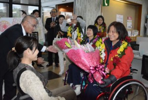 歓迎の花束を受け取る（右から）蕭さんと盧さん＝１７日、龍郷町役場