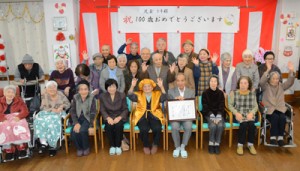 万歳で１００歳の節目を喜ぶ児玉トキさん（前列中央）＝１５日、奄美市名瀬