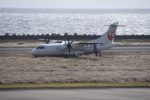 着陸時に滑走路を外れて草地に進入したＪＡＣ機＝８日午前１１時ごろ、奄美市笠利町の奄美空港