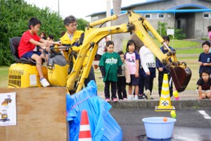 ショベルカーの試乗体験をする子ども＝１９日、喜界町早町の塩道長浜公園