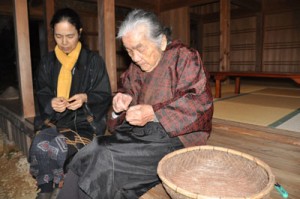 イトバショウの繊維をつないで糸を作る、与論民俗村の菊千代さん（右）と友子さん＝１２日、与論町