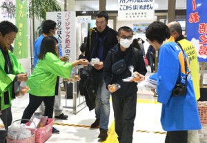 鹿児島からの乗客へ徳之島産タンカンを贈る農家や行政担当者＝１６日、天城町の徳之島空港