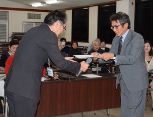 地域通訳案内士の研修修了証を受け取る試験合格者＝２１日、奄美市名瀬
