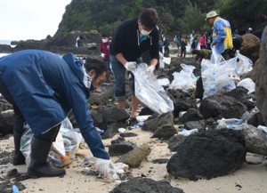 砂浜でごみを回収した参加者＝１５日、奄美市笠利町のあやまる岬北側の海岸