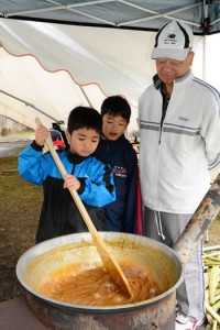 地域住民に教わりながら黒糖を作る児童＝１月３０日、大和村の大和小学校