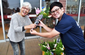 花束を笑顔で受け取る女性＝１４日、知名町