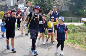 青空の下、えらぶ路を元気に歩く大城小の６年生や保護者、教諭ら＝２９日、和泊町谷山