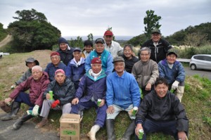 今帰仁村との友好都市締結を記念し、フクギの植樹を行った「花と緑を育む有志の会」のメンバーら＝１８日、和泊町