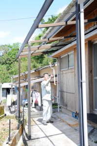 テラス屋根が飛ばされるなど被害にあった住家＝２９日午前１１時半ごろ、奄美市名瀬佐大熊