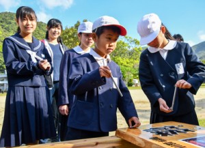 看板を設置する児童生徒たち＝１６日、瀬戸内町の篠川小中学校 