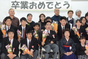 卒業式後、クラスメートや保護者らと記念写真を楽しむ鈴倉さん（前列中央）＝２日、奄美市笠利町