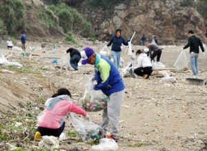 海岸のごみを拾う参加者＝４日、奄美市笠利町佐仁の楠野海岸