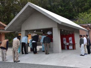 係者らが手水舎の完成を祝った竣工祭と自動給水式を採用した水栓＝３日、奄美市名瀬の高千穂神社
