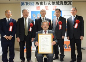 あましん地域貢献賞を受賞した徳之島虹の会の政理事長（前列）＝３日、奄美市名瀬