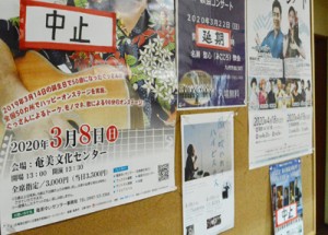 中止の張り紙が目立ち始めたアーマイナープロジェクトの掲示板＝５日、奄美市名瀬金久町