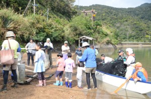 網を仕掛けるのを手伝う参加者。写真奥が見張り台＝１日、宇検村芦検