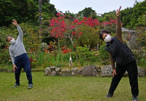 庭先で島口ラジオ体操に汗を流す町民＝１１日、龍郷町