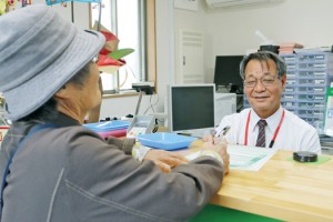 地域の高齢者に笑顔で対応する村田局長