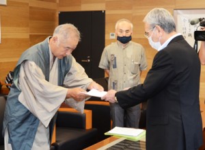 朝山市長に要望書を手渡す前田理事長（左）＝１８日、奄美市名瀬