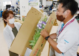 沖永良部島産の切り花詰め合わせを受け取る購入者＝１４日、和泊町