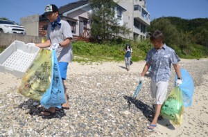 倉崎海岸の浜辺で清掃を行う龍郷ダイビング組合のメンバー＝１４日、龍郷町芦徳