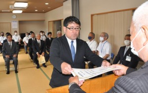 森委員長（右）から当選証書を受け取った８人の新議員ら＝２５日、大和村防災センター