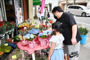 生花店の店先で母の日用のプレゼントを選ぶ来店者＝９日、奄美市名瀬