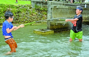 ジッキョヌホーで水遊びを楽しむ子どもたち＝２１日、知名町