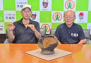 ウンブキ内部で見つかった縄文土器について説明する広部氏（左）と森田町長＝２３日、天城町役場